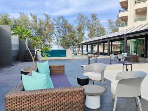 宋卡Solis Beach Hotel Rajamangala的天井配有沙发、桌椅