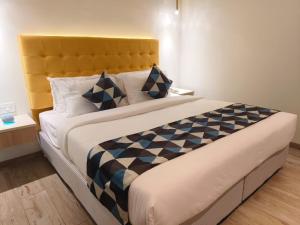 维沙卡帕特南World Inn Hotel的一间卧室配有一张带黄色床头板的大床