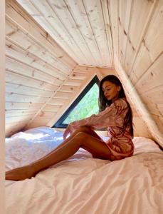 卡兹贝吉Kazbegi Kuro Cottages的坐在帐篷里的床上的女人