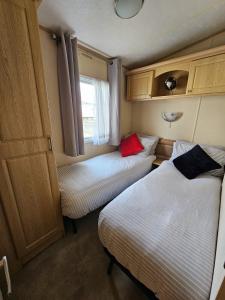 TossideVacanza Static Caravan的小房间设有两张床和窗户