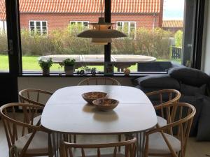 阿森斯Funen Cottage With Fantastic Sea View,的一张白色的桌子和椅子,上面放着碗