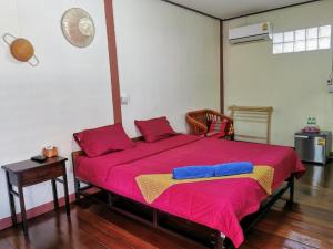 大城Chanida home的一间卧室配有一张大床,铺有红色和蓝色的床单