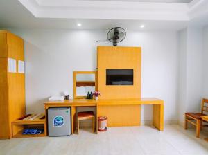 岑山UFJ HOTEL Sầm Sơn的客房设有书桌、桌子和电视。
