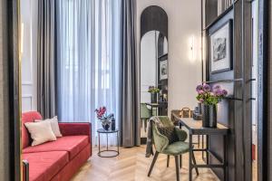 罗马Residenza Piranesi Boutique Hotel的客厅配有红色的沙发和桌子