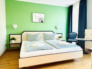 洛布F-1010 Strandhaus Mönchgut Bed&Breakfast DZ 28 Terrasse strandnah, inkl Frühstück的一间卧室配有一张带绿色墙壁的床