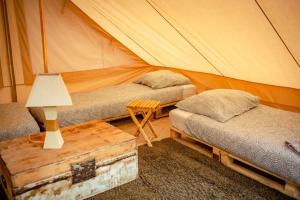 圣伊莱尔德里耶The Spot - 200m de la Plage的帐篷配有两张床和一张带台灯的桌子