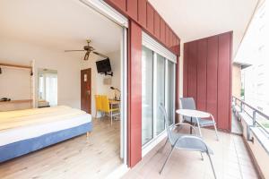 卢加诺艾特兰蒂科酒店的卧室配有一张床和一张桌子及椅子