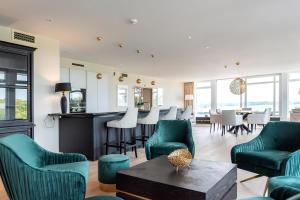 格吕克斯堡Intermar Hotel & Apartments的客厅配有绿色椅子和桌子