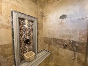 恰乌辛Cappadocia Fairy Tale Suites的一间带镜子和淋浴的浴室