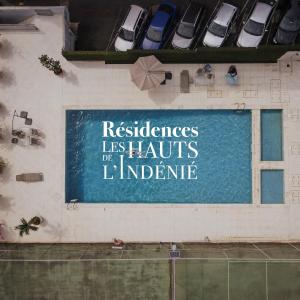 阿比让Résidences Les Hauts de l'Indenié的建筑物一侧有停车车辆的标志