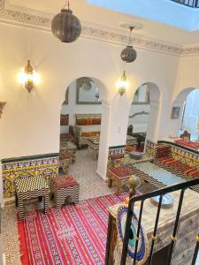 丹吉尔Zoco Riad的一间客厅,地板上铺着色彩缤纷的地毯