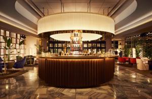 巴塞罗那Grand Hyatt Barcelona的酒店大堂的酒吧,配有大吊灯