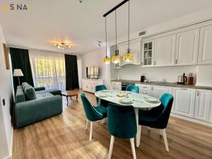 锡纳亚SINAI APH Apartments的厨房以及带桌椅的起居室。