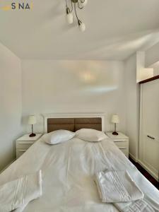 锡纳亚SINAI APH Apartments的白色的床、白色床单和枕头