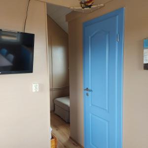 韦斯特曼纳埃亚尔Ofanleiti Cottages的一张蓝色的门,位于带床的房间