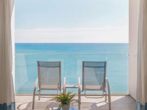 贝纳尔马德纳Hotel Benalmadena Beach的两把椅子坐在靠近大海的庭院