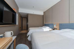 张家界Home Inn Zhangjiajie Tianmen Mountain Branch的酒店客房设有两张床和一台平面电视。