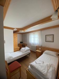奥瓦罗艾波利斯酒店的一间设有两张床和椅子的房间