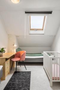 特罗姆瑟Boukersen Heim的一间设有婴儿床、一张桌子和一把椅子的客房