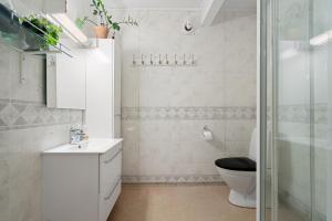 特罗姆瑟Boukersen Heim的浴室配有卫生间、盥洗盆和淋浴。