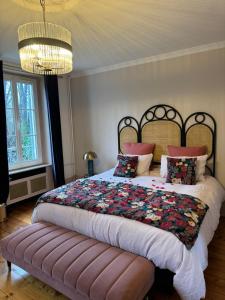 Asnières-sur-Oise勒克洛德菲住宿加早餐旅馆的一间卧室配有一张大床和一个吊灯。
