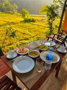 马特勒Sinharaja Cabana的田野上带食物盘的木桌