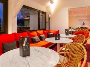 尚布雷莱图尔图尔南宜必思酒店的客厅配有两张桌子和一张红色沙发
