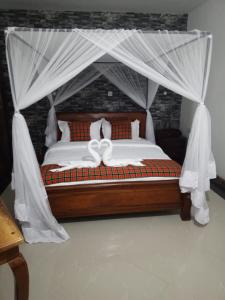 基苏木Queen's Way Resort的一间卧室配有一张带天蓬的床