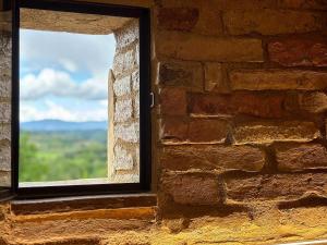 圣吉米纳诺佩德里贝拉维斯塔酒店的砖墙的窗户,享有美景