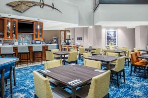 查尔斯顿Hilton Garden Inn Charleston / Mt. Pleasant的一间带桌椅的用餐室和一间酒吧