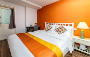 西安西安西唐客栈的一间卧室配有一张带橙色墙壁的大床