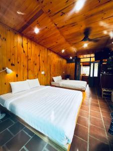 大叻Lam Vien Garden Villa - Homestay Da Lat的卧室配有木墙内的两张床