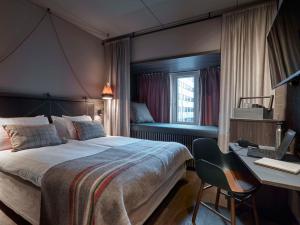 斯德哥尔摩斯堪迪克坎佩尔市区酒店的一间卧室配有一张床和一张带电脑的书桌