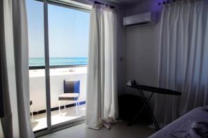 肯杜瓦SunSeaBar Beach Resort的一间卧室设有窗户,享有海滩美景