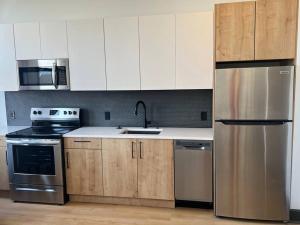 伯明翰Urban Luxe Studio的厨房配有白色橱柜和不锈钢冰箱