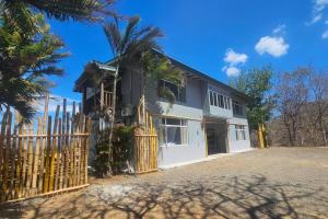 拉克鲁斯Villa Ballena Art Project的一座带围栏和棕榈树的房子
