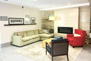 马修斯Wingate by Wyndham Matthews, NC的带沙发和红色椅子的客厅