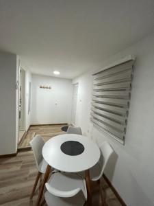 特雷比涅Apartman Dušan Trebinje的一间配备有白色桌椅的用餐室