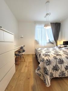 皮拉Widokówka的一间卧室配有一张床、一张书桌和一个窗户。