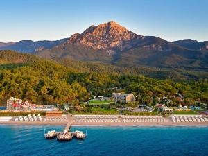 特基罗瓦Movenpick Resort Antalya Tekirova的水中的一个岛屿,以群山为背景