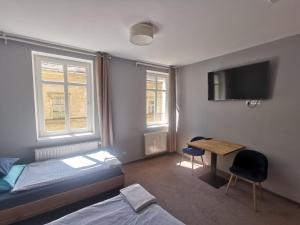 弗罗茨瓦夫Bemma Apart Hostel的一间卧室配有一张床、一张书桌和一台电视。