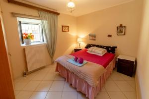 圣马太奥斯Krasa 2bedroom apartment的一间卧室配有一张带红色床单的床和一扇窗户。