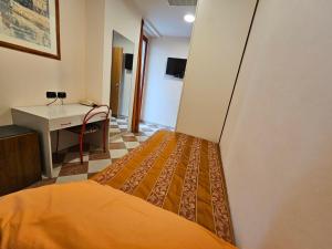 西尼加利亚菲奥瑞拉酒店的一间卧室配有一张床、一张桌子和一个水槽