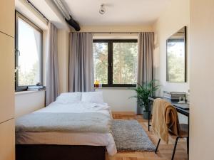 塔林Stereo House by Larsen的卧室配有一张床、一张书桌和窗户。