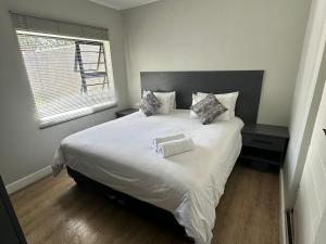 昆斯敦Conti-INN Guesthouse的卧室配有一张大白色床和窗户
