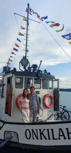 萨翁林纳Saimaa Experience的站在船前的男人和女人