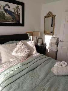 普雷斯科特House Rose 1的一间卧室配有带枕头和镜子的床