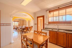 穆罗海滩Villa Pons的一间带木桌的厨房和一间餐厅