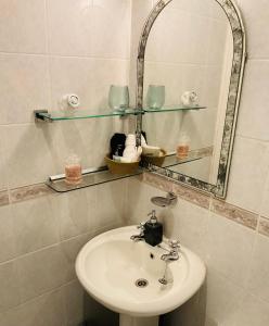 滨海韦斯顿All Seasons Bed & Breakfast - Adults Only的一间带水槽和镜子的浴室