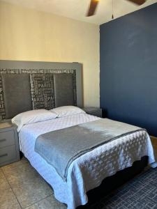 萨尔蒂约Recámara cedro的一间卧室设有一张蓝色墙壁的大床